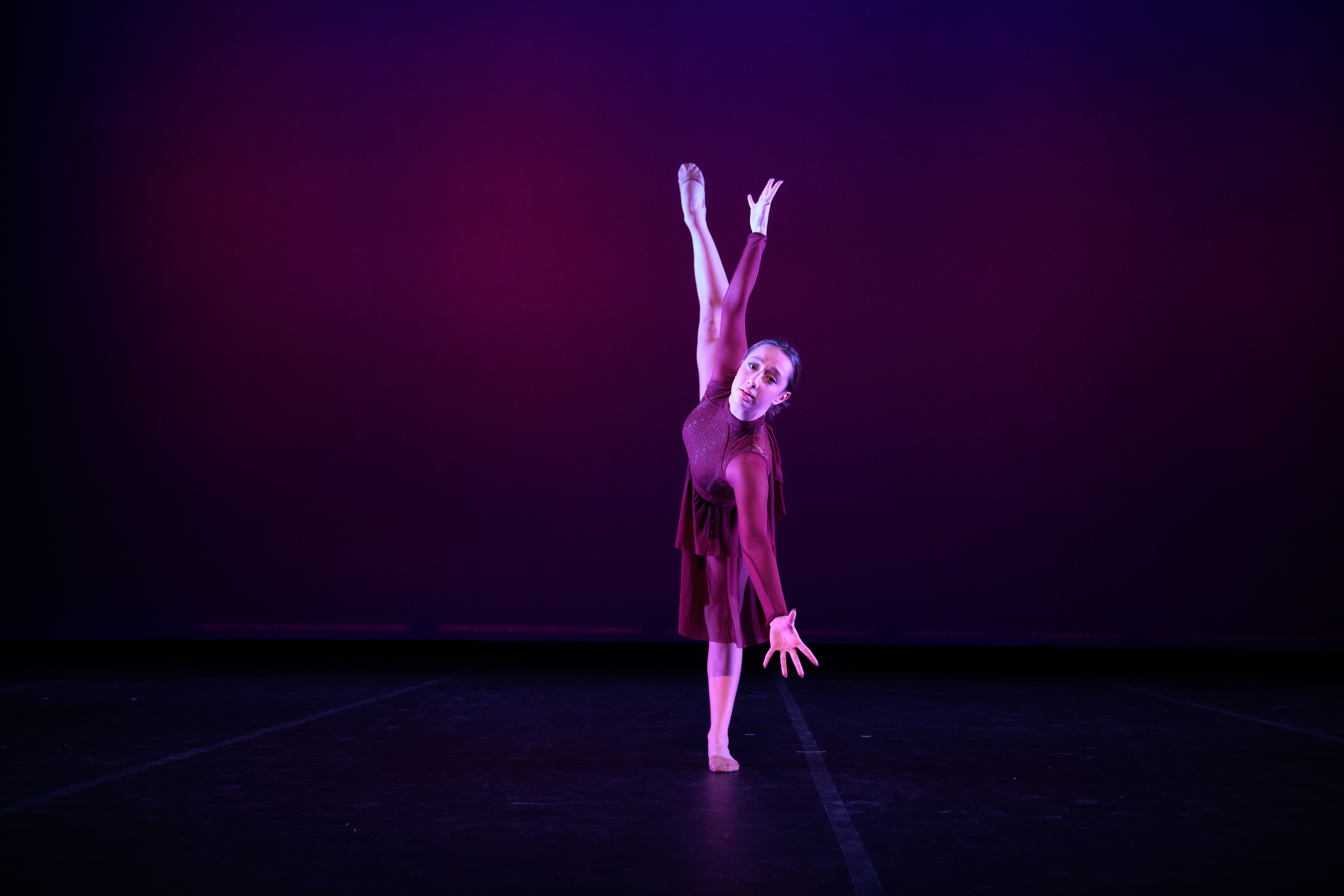 dancer in burgundy dress on stage