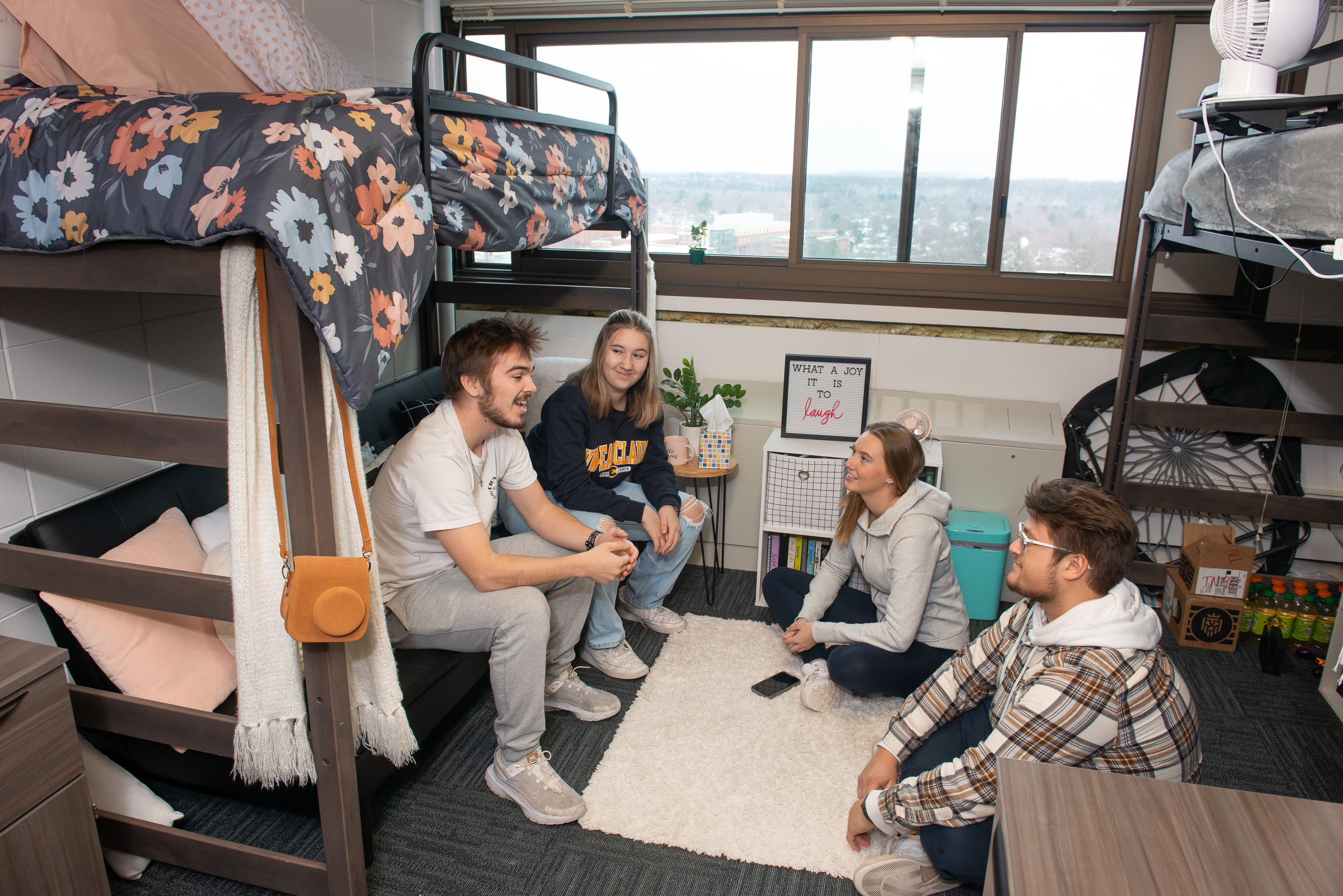 Students sitting together and having a conversation in a residence hall room.