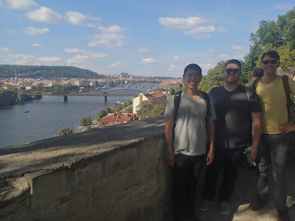 Three student during study aboard in Prague taking a picture with city view