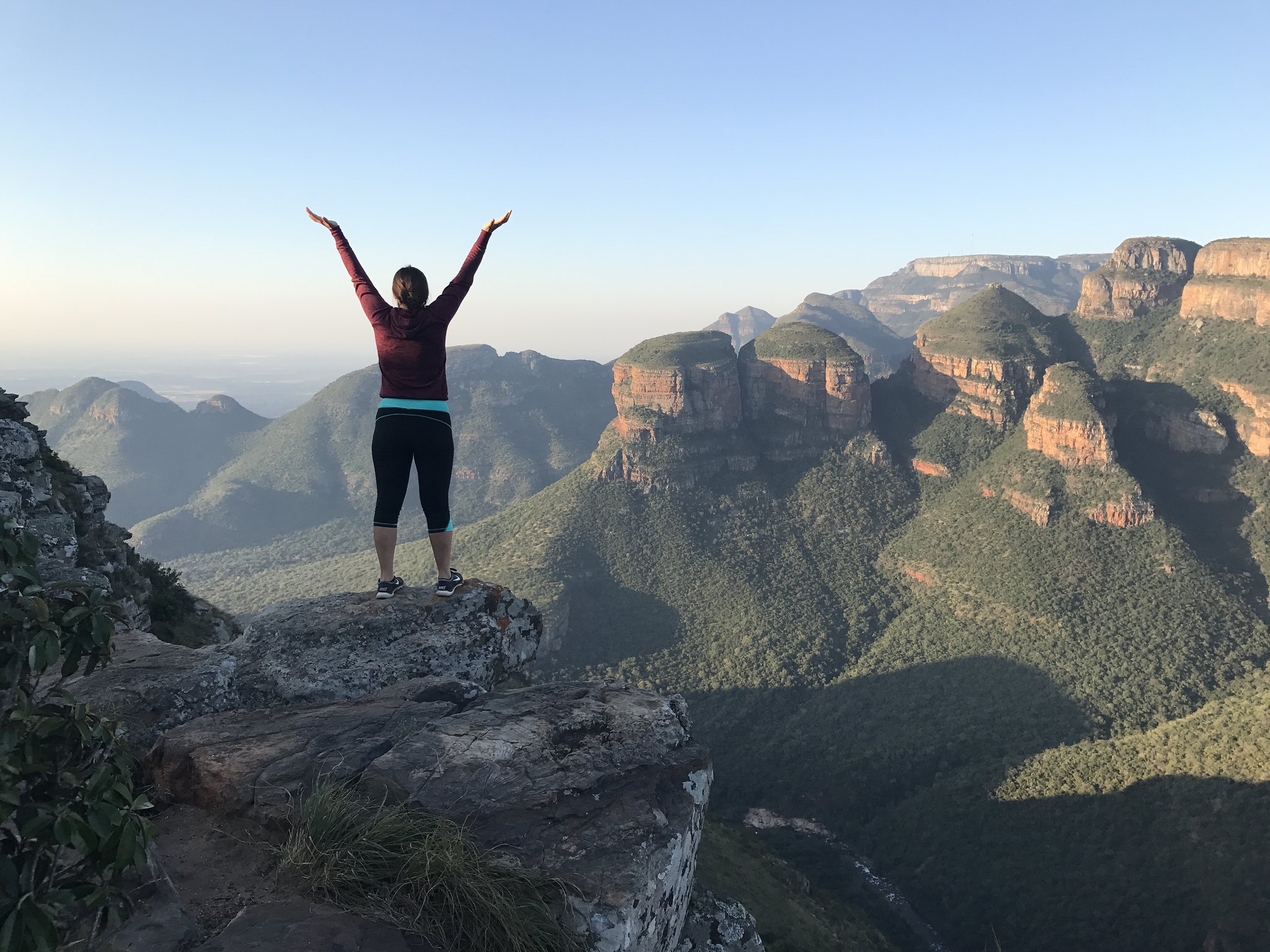 a picture of student during study aboard in South Africa on top of the rocky outcrop, with a breathtaking view of the Blyde River Canyon in South Africa