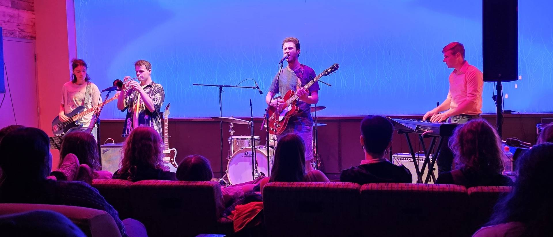 Four band members performing in The Cabin