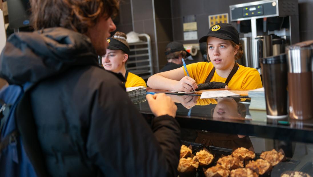 A person places their order at the counter in Einstein's Bagels.