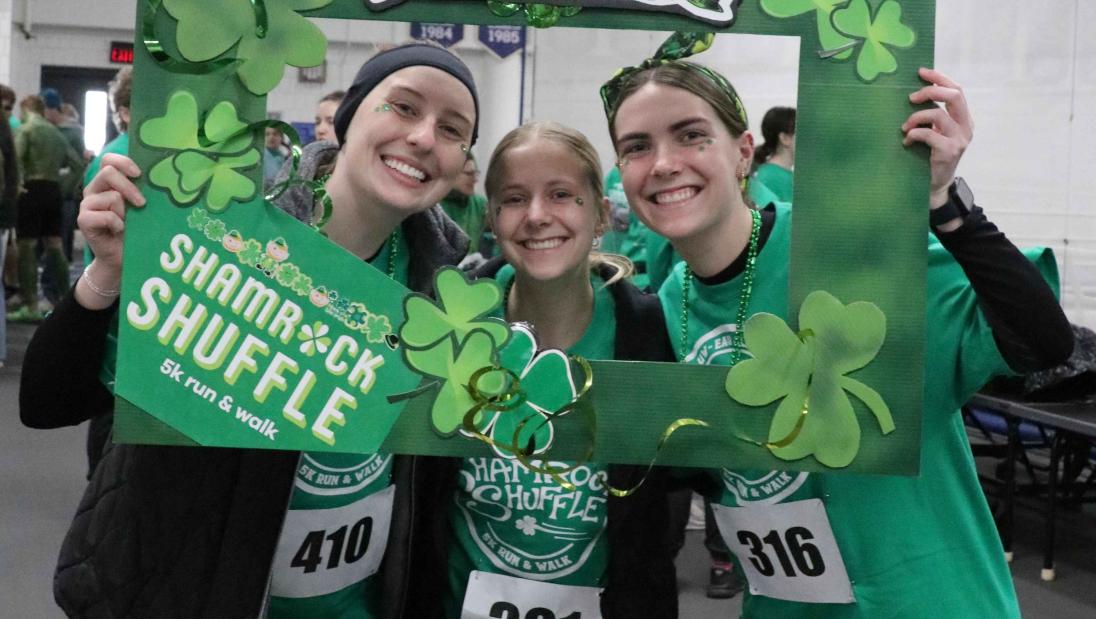 Group of runners posing in St. Patricks Day Themed frame