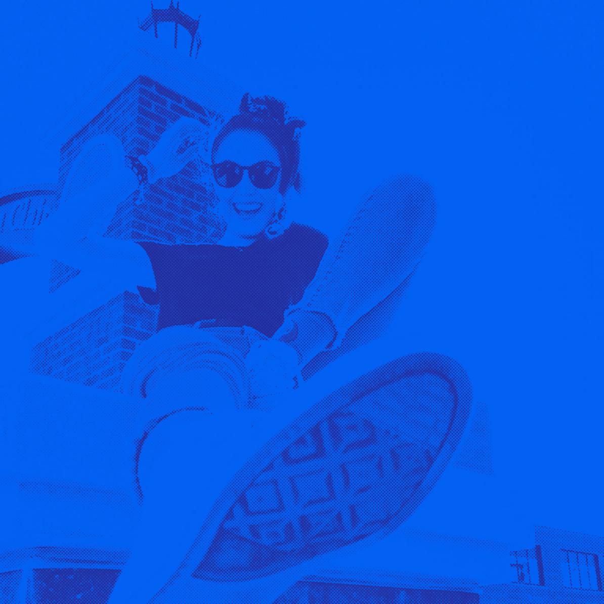 A blue monotone image of a girl sitting on a chimney