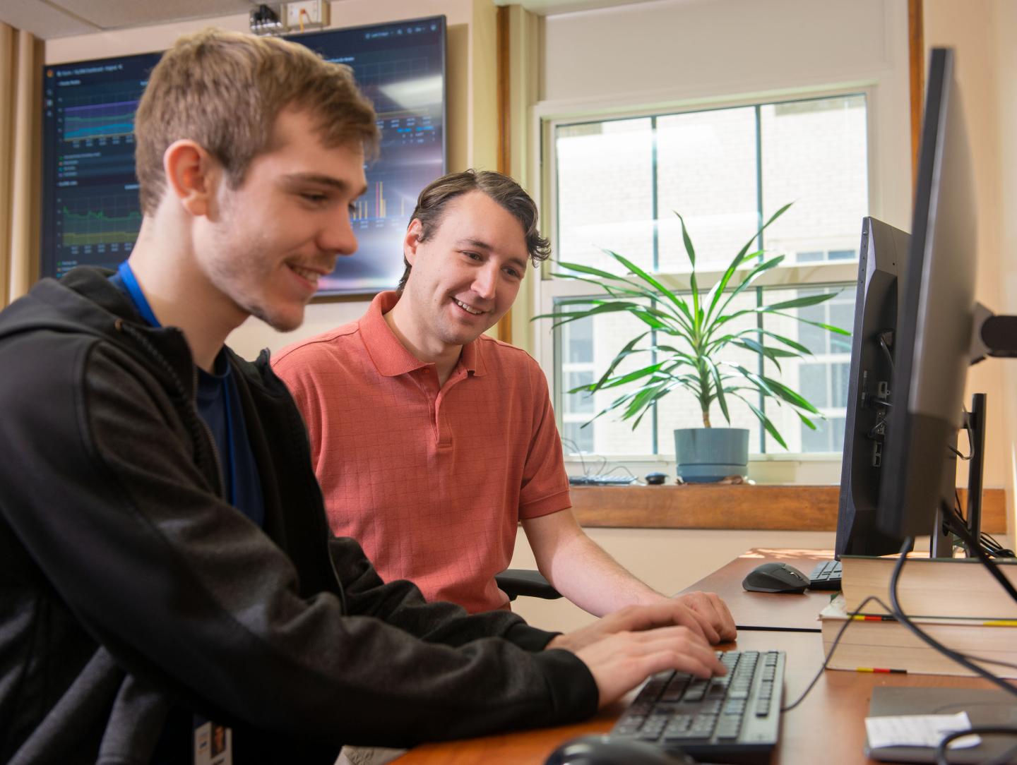 Staff working with a student at a computer station