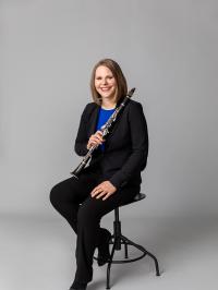 Dr. Alyssa Powell sitting on stool with clarinet. 