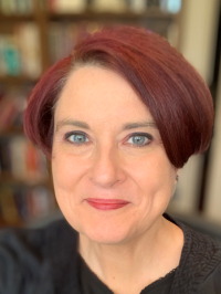 Woman with red hair and green eyes smiling