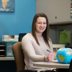 Courtney Brost smiling while working in the Center for International Education