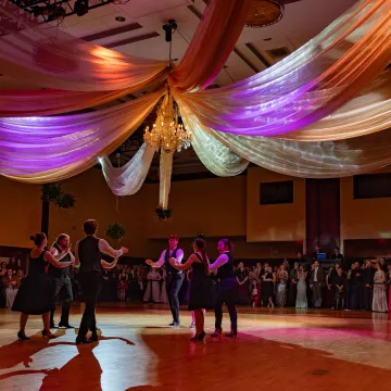 six students in the center of the ballroom at V Ball 