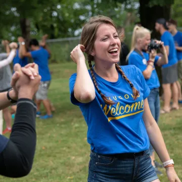 A student in BluGolds welcome shirt participating in an outdoor event for incoming transfer students at UWEC