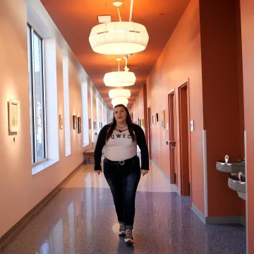 Student walking down the Graham Avenue Walking Gallery at the Pablo Center