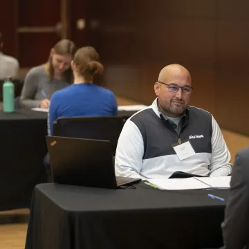 Student talking with an employer at mock interview day event.