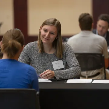 Student talking with an employer at mock interview day event.