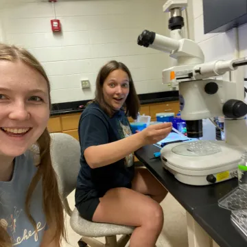 2 students smiling in lab