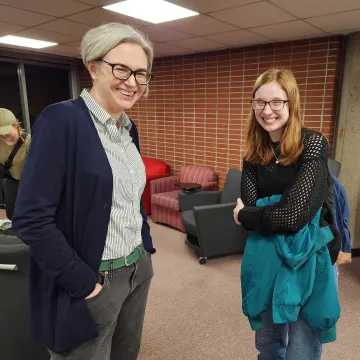 faculty member and student standing and smiling