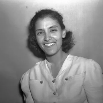 Black and white photo of a young woman smiling at the camera.