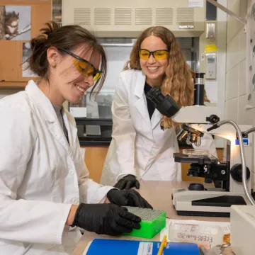 Student and faculty at microscope conducting research