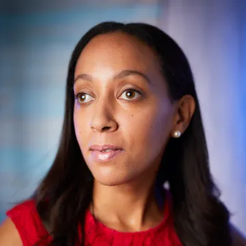 A woman poses to a camera in profile. 