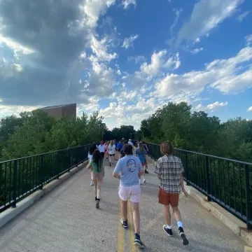 Students waling across footbridge to downtown farmers market