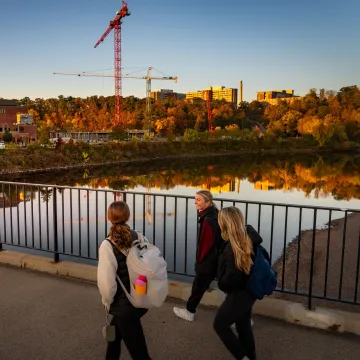 students on footbridge, fall scene 