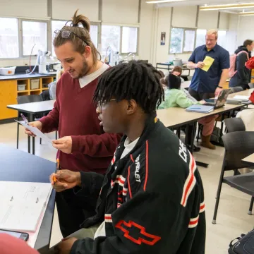 students in small group in science room, discussing 