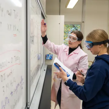 chemistry lab students and faculty at white board 