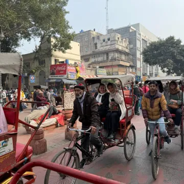 busy street of New Delhi, India with Blugolds waving from a rickshaw