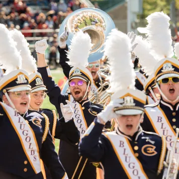 Blugold Marching Band members cheer at a football game