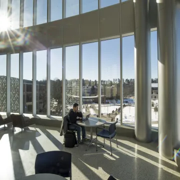 Student studying in sunny windows of Centennial Hall during winter