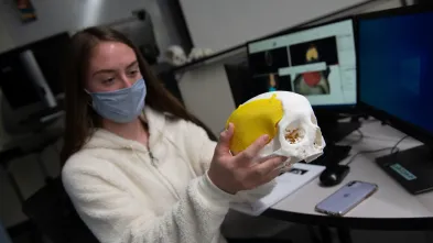 3D printed skull and digital images behind on screen 