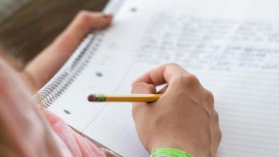 student writing in a notebook