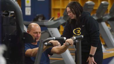 student working with client in workout class