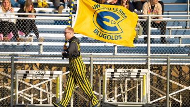 student walking with athletics flag at a track meet 