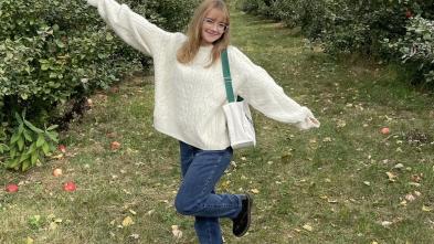 Sabrina Massie in a field, smiling with her arms out.