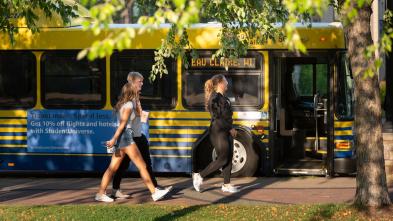 Students walking to enter the city bus on campus
