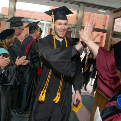 High fives for Dean Manning from male COEHS grad 