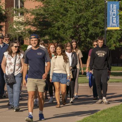 student leading a tour group outdoor on campus 