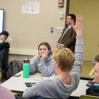 student raising hand in class