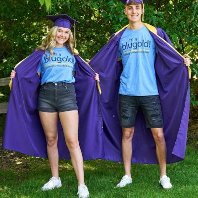 Two students graduating from high school show off their Blugold attire.