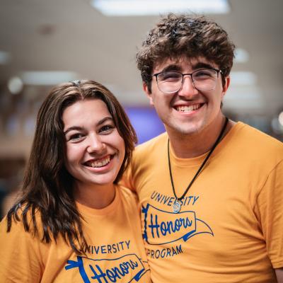 two students wearing gold University Honors Program t-shirts 