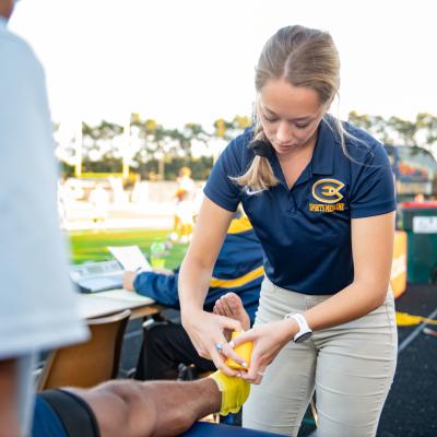 Student taping an ankle during a UWEC soccer game