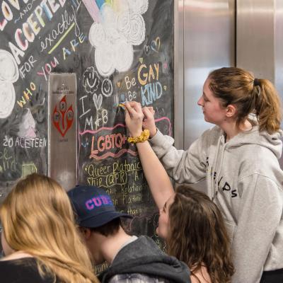 Students drawing on the chalkboard on the Rainbow Floor