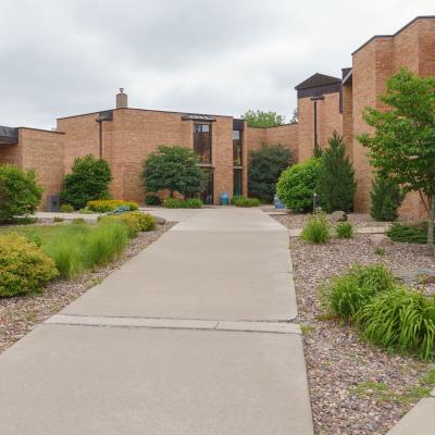 Exterior photo of Priory Hall, a brick residence hall with landscaping and sidewalks