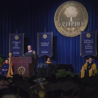 male alumni awardee giving the "Charge to the Class" address in ceremony