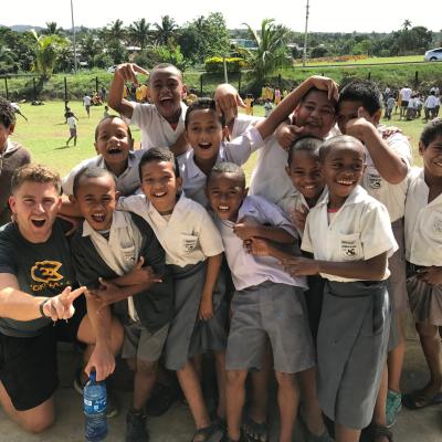 UWEC student poses with Fiji school children