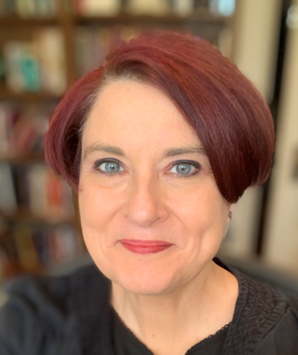 Woman with red hair and green eyes smiling