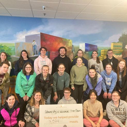 An image of a group of college students from the UWEC doing service work providing 7,574 meals in the immersion trip to Indianapolis