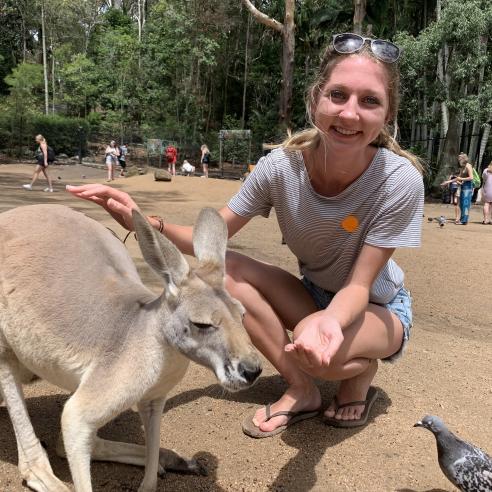 A student on a study abroad program in Lismore, Australia, taking picture next to a kangaroo.