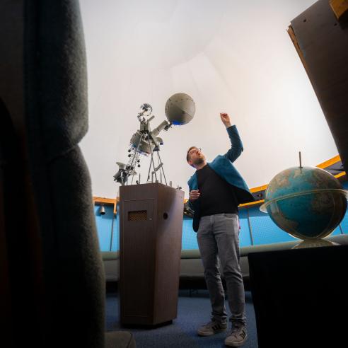 faculty member talking to a group in the planetarium