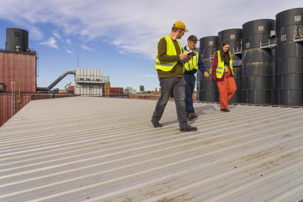 three people in safety gear walking on a rooftop at Banbury Place in Eau Claire